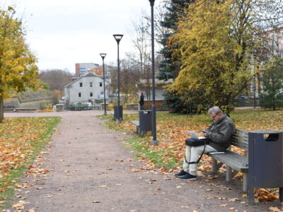 Park in the vicinity of the border crossing. Is the man waiting to cross, or enjoying working in the fresh air of the chilly October afternoon?